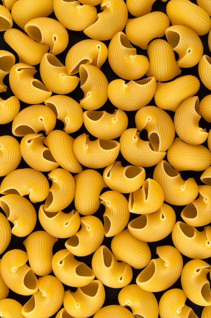 Pipe rigate pasta pattern on black background top view flat lay texture