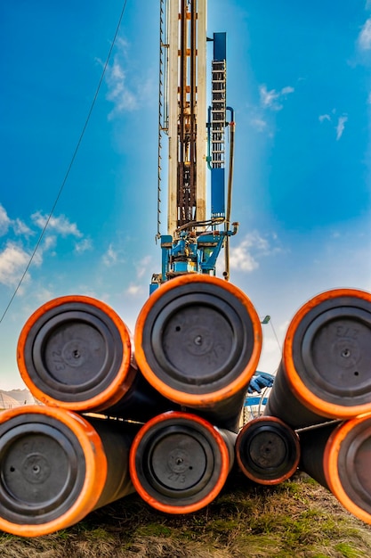 Pipes for a well closeup Powerful drilling rig against a cloudy sky Drilling of deep wells Drilling equipment Mineral exploration Extraction of gas and oil