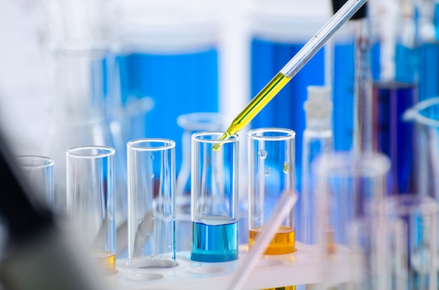 A pipette dropping sample into a test tube, abstract science