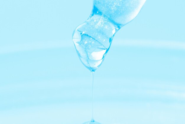 Pipette with dripping blue liquid Or blue liquid Closeup On a blue background Laboratory chemistry medicine Cosmetic research shine