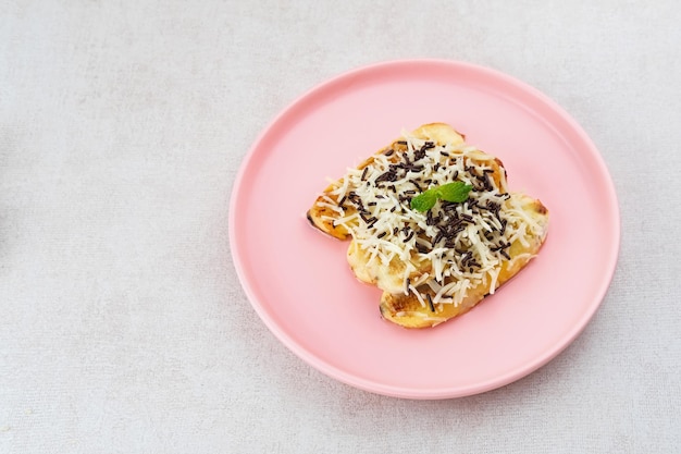 Pisang panggang Grilled banana topped with chocolate sprinkles grated cheese and sweet white milk