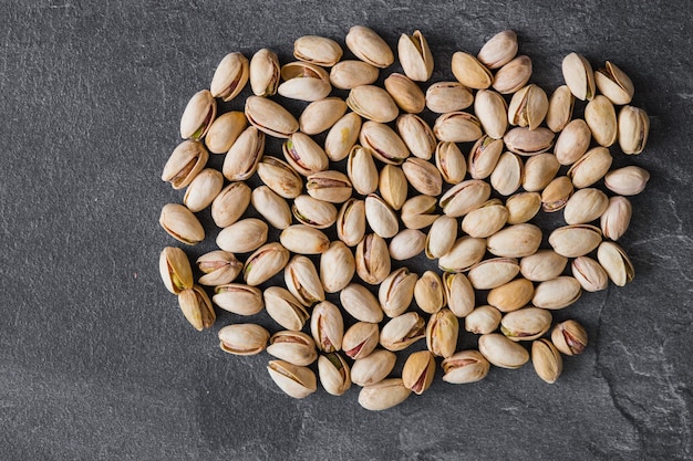 Pistachio nuts on a dark background Healthy snacks Top view Free space for text