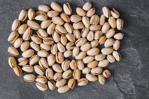 Pistachio nuts on a dark background Healthy snacks Top view Free space for text