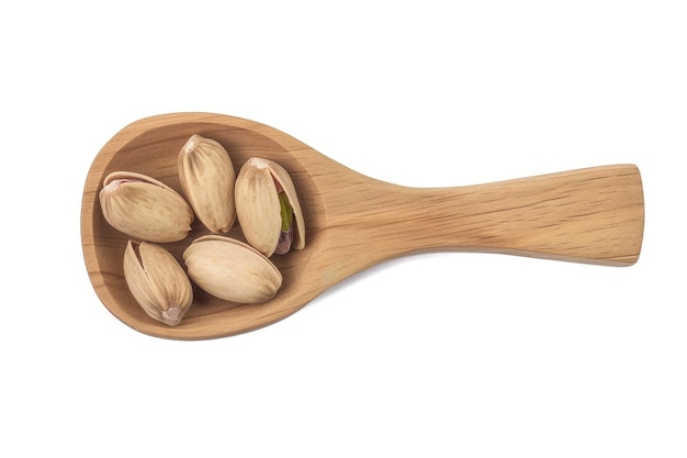 pistachio nuts with shell in the wooden spoon isolated on the white background top view