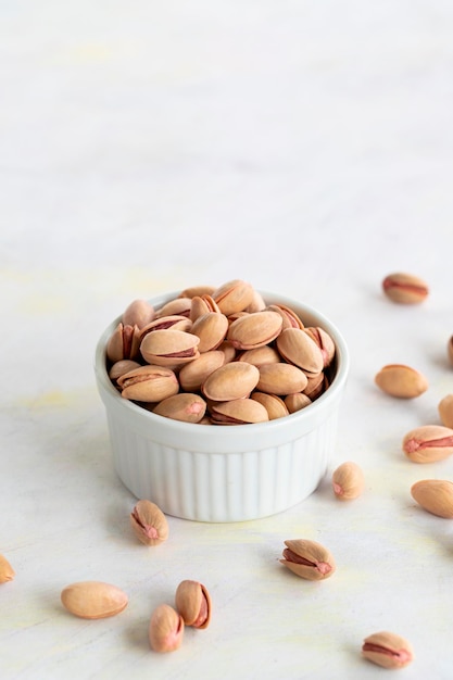 Pistachios on a white wooden background