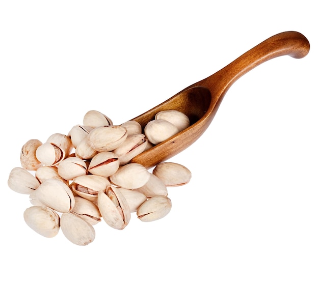 Pistachios in the wooden spoon isolated on white background