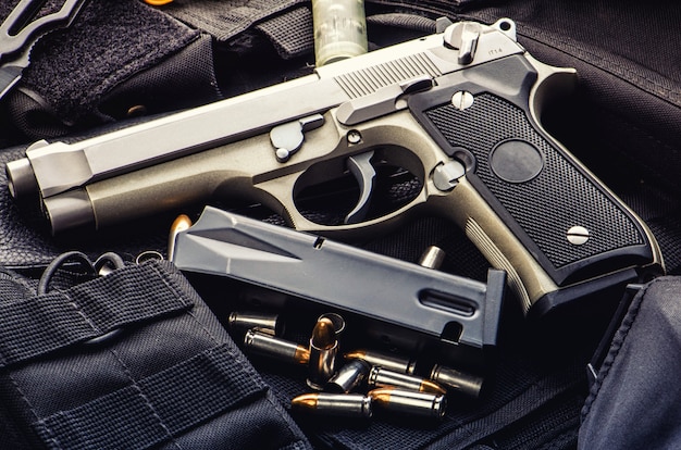 pistol gun bullets and magazine strewn on wooden table