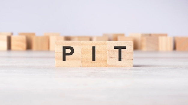 PIT word concept written on wooden cubes or blocks on a light background