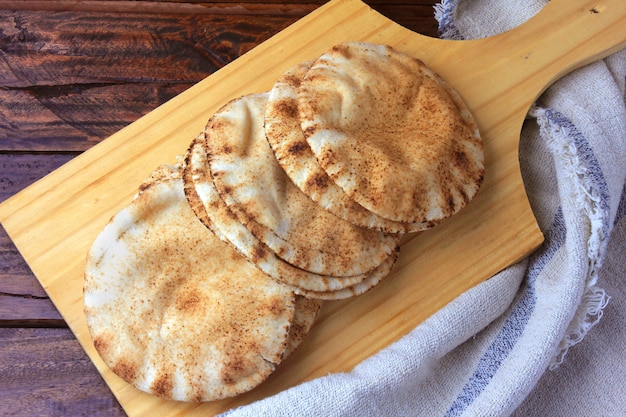 Pita bread isolated on wooden spatula coming out of the oven