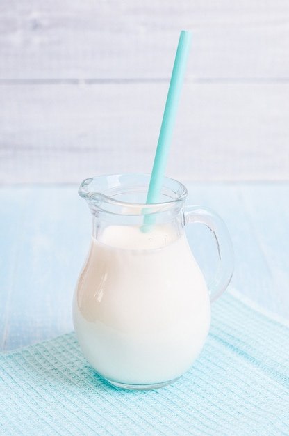 Pitcher glass of milk with straw