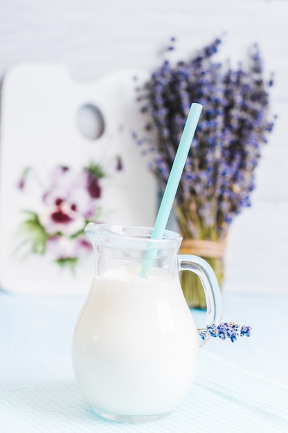 Pitcher glass of milk with straw