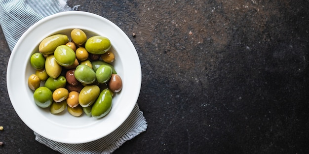 pitted olives in a plate on the table different varieties of fruits  vegan or vegetarian