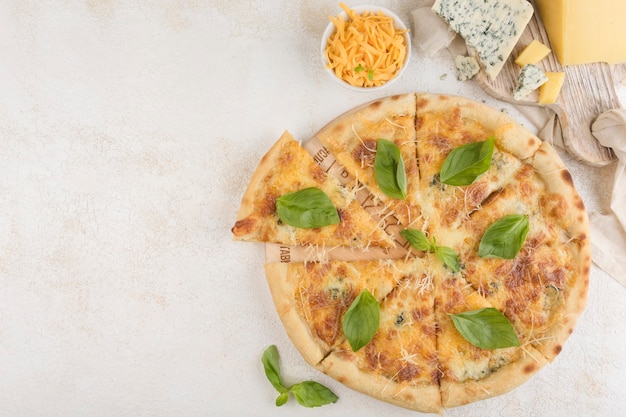 Pizza 4 cheeses with Caesar sauce, Cheddar cheese, Marble cheese, Parmesan cheese, Mozzarella cheese and olives on a light background. Top view with a copy space for the text. Classic Italian food.