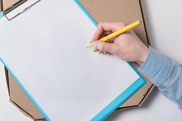 Pizza box and male hand puts a signature on the document Food delivery to house concept