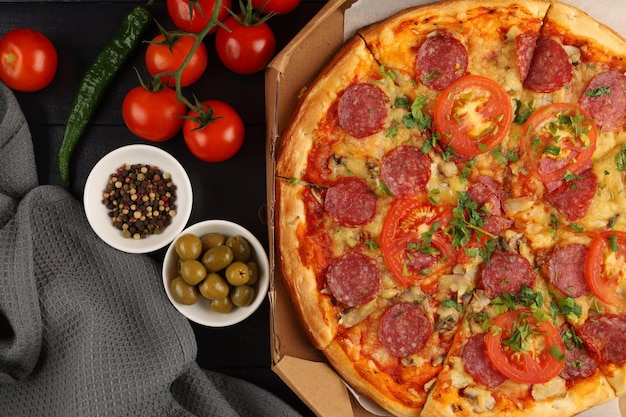 Pizza in a box on the table Hot pizza with vegetables Pizza in a restaurant