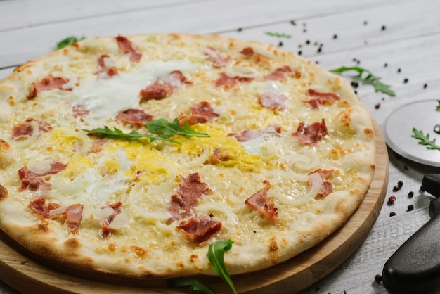 Pizza Carbonare with mozzarella, becon, egg and onion on the white background