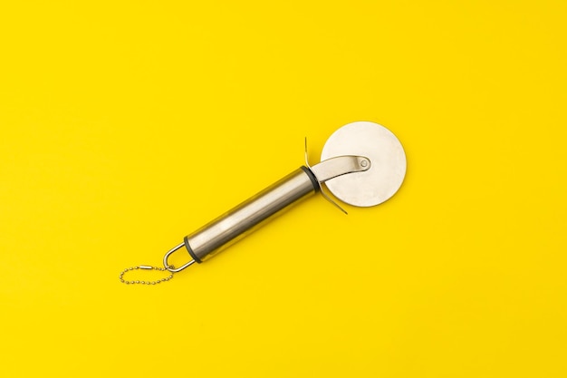 Pizza cutter on yellow background