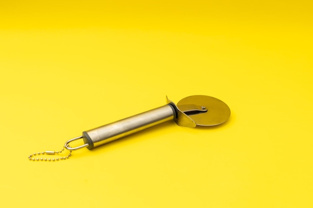 Pizza cutter on yellow background