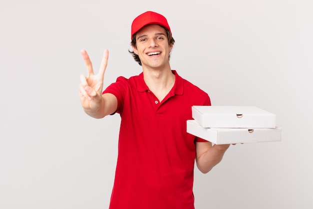 Pizza deliver man smiling and looking friendly, showing number two