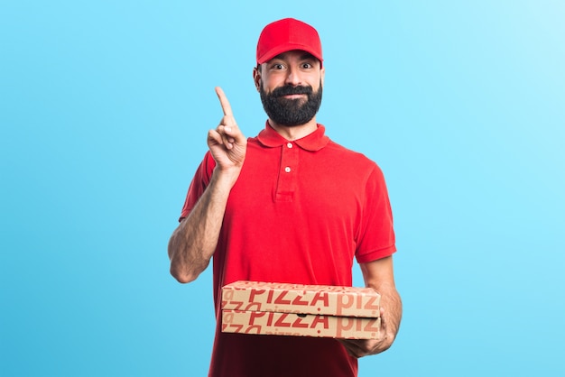 Pizza delivery man pointing up on colorful background