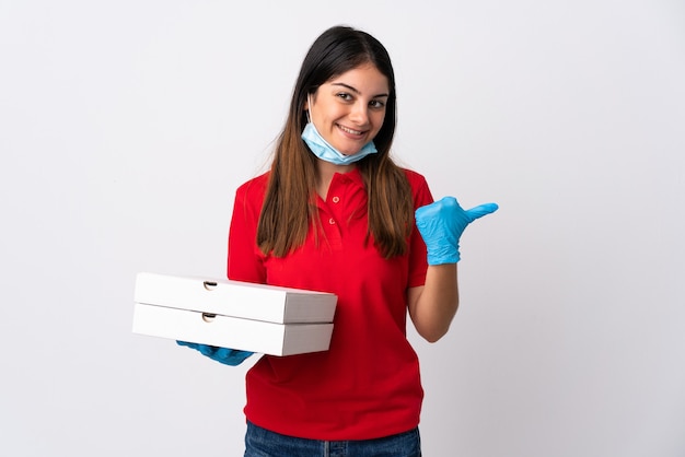 Pizza delivery woman holding a pizza isolated on white pointing to the side to present a product