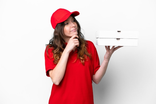 Pizza delivery woman with work uniform picking up pizza boxes isolated on white background and looking up