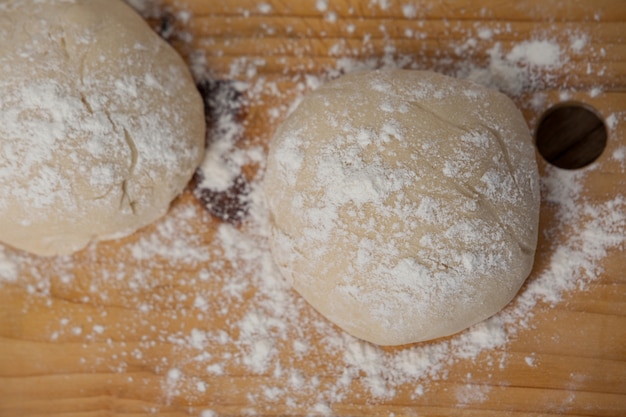 Pizza dough and flour on chopping board