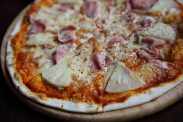 Pizza hawaiian , pizza with pineapple and ham with cheese and tomatoes sauce on wood background , italian food