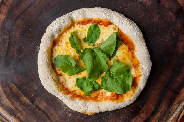 Pizza Homemade cheese pizza with arugula over wood