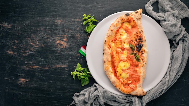 Pizza Italian traditional dish On a wooden background Top view Free copy space