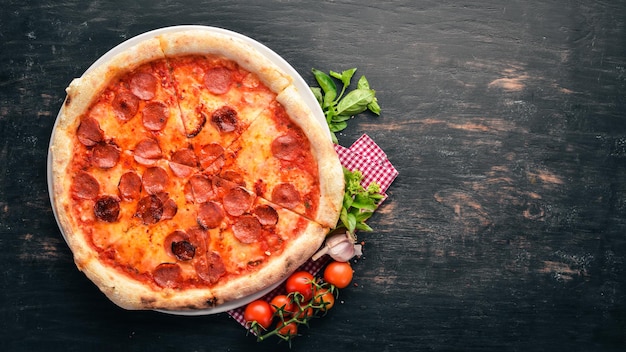 Pizza Margarita with sausages and tomato sauce On a wooden background Top view Free space for your text