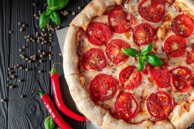 Pizza Margherita on black background top view Pizza Margarita with Tomatoes Basil and Mozzarella Cheese