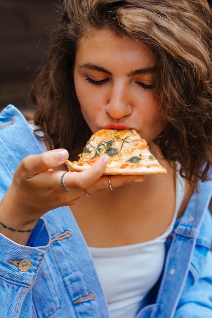 Pizza time Pretty smiling woman eating pizza in the restaurant