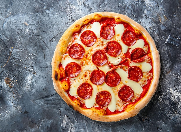 A pizza with cheese on it on a dark background