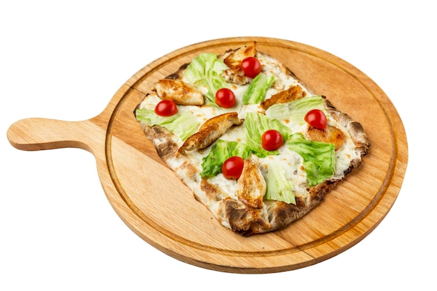 Pizza with chicken lettuce leaves and cherry tomatoes on a wooden board for serving Appetizing traditional Italian dish Top view Closeup Isolated on white background