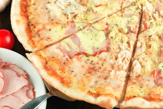 Pizza with ham, cheese and chicken close-up