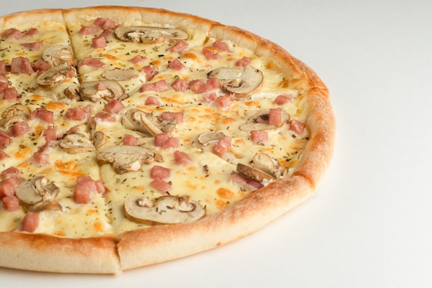 Pizza with ham mushrooms oregano and cheese on a white background