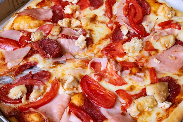 Pizza with meat and tomatoes close up