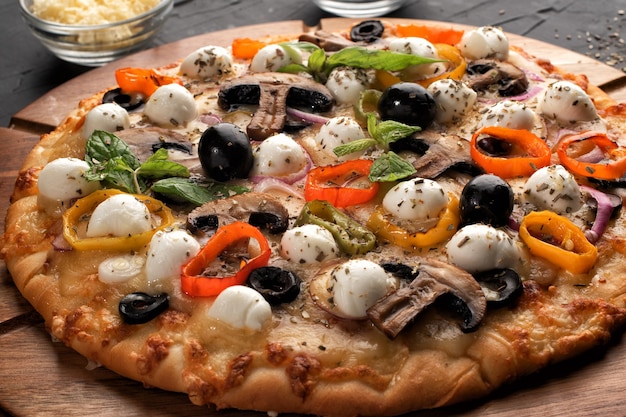 Pizza with mozzarella ,olives and mushroom. Italian cuisine. Ingredients for making pizza on a black background.Concept for advertising restaurants or pizzerias.