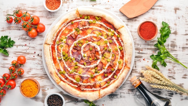 Pizza with onions sausage and cucumber On a wooden background Top view Free space for your text