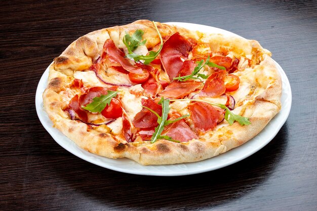 Pizza with Parma ham and cherry tomatoes On a wooden background