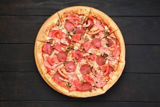 Pizza with salami mushrooms and tomato