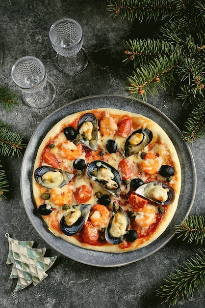 pizza with seafood mussels in shells, shrimp tails, capers and olives