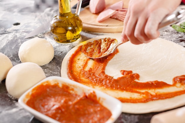 Pizzaiolo prepares pizza in the kitchen the chef prepares the dough