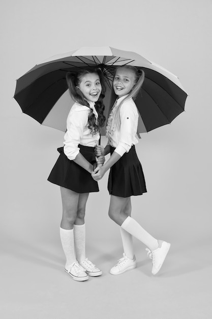 Place for both of us Fashion accessory Girls friends with umbrella Rainy day Happy childhood School time Rainbow umbrella Colorful life Schoolgirls happy big umbrella Fall weather forecast