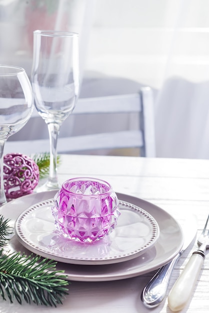 Photo place table setting for christmas white table with purple decor elements with green branches christmas tree