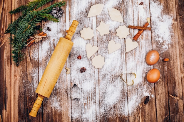 Place on the wooden table with rolling pin, dough, eggs and flour for cooking Christmas pastry