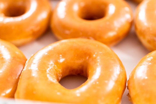 Plain glazed store-bought doughnuts in a white paper box.