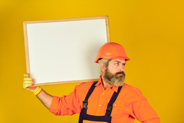 Plan repair works. Architect showing project. Professional repairman. Visual outline. Troubleshoot concept. Bearded man repairman builder. Repairman hold whiteboard copy space. Handsome repairman.