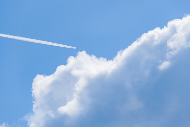 Plane flying in the cloudy blue sky